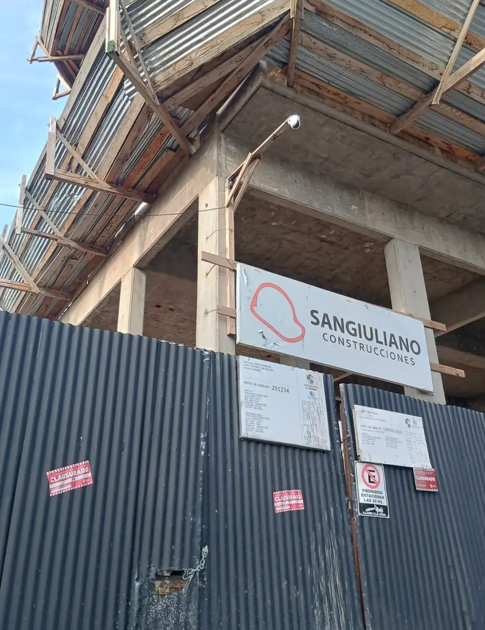 Portón de acceso del edificio con el cartel de clausura.